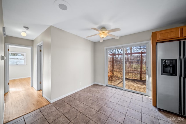 spare room featuring ceiling fan, light wood-type flooring, and a wealth of natural light