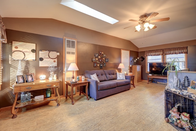 living room with lofted ceiling with skylight, hardwood / wood-style floors, and ceiling fan