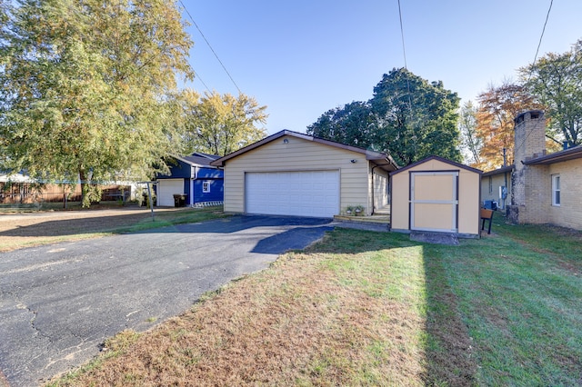 view of front of house featuring a front yard, a storage shed, and a garage