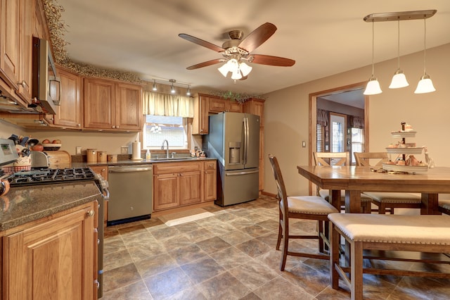 kitchen with sink, ceiling fan, appliances with stainless steel finishes, and decorative light fixtures