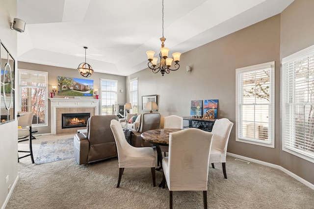 dining area featuring carpet flooring, a fireplace, and a healthy amount of sunlight