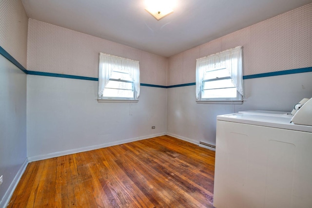 washroom featuring a wealth of natural light, dark hardwood / wood-style flooring, washer / clothes dryer, and a baseboard radiator