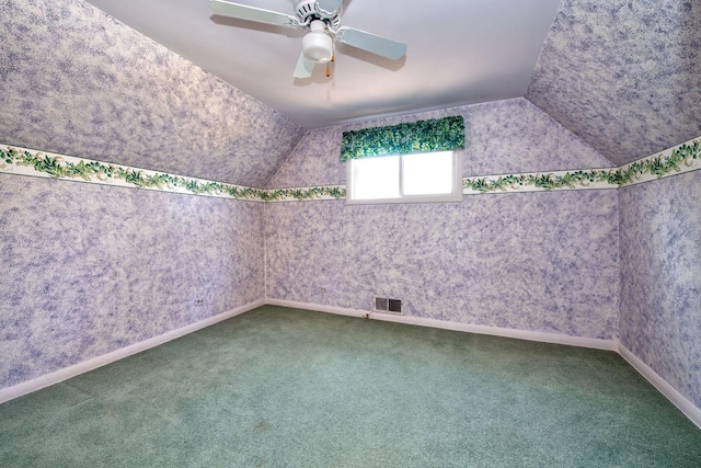 carpeted spare room featuring ceiling fan and lofted ceiling