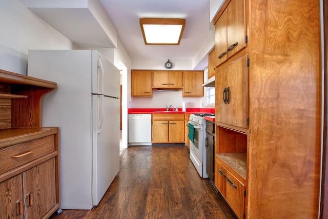 kitchen featuring white appliances, dark wood-type flooring, and sink