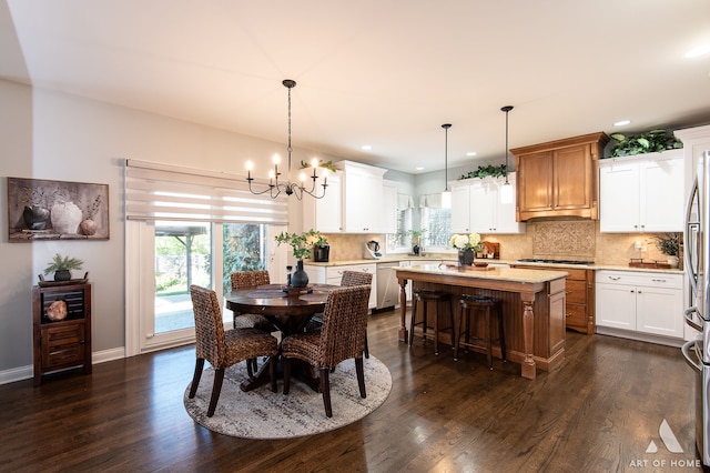 dining room with an inviting chandelier, dark hardwood / wood-style floors, and a healthy amount of sunlight