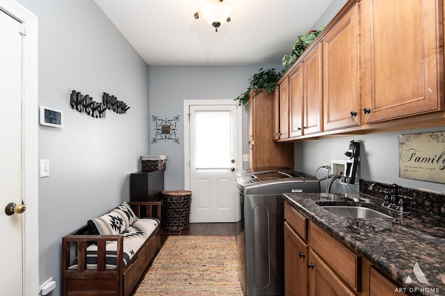 laundry area with sink, independent washer and dryer, wood-type flooring, and cabinets