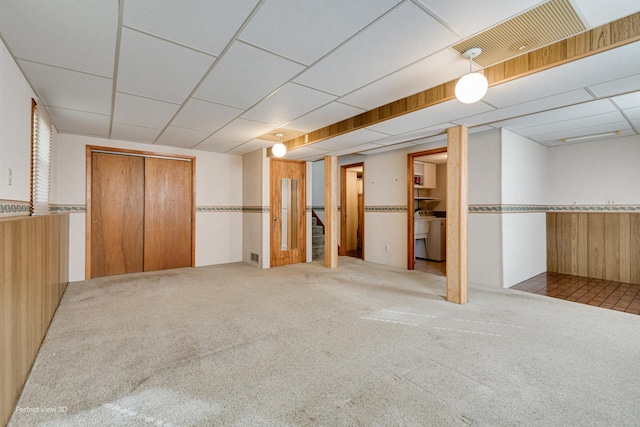 interior space with stairway, a drop ceiling, and carpet flooring