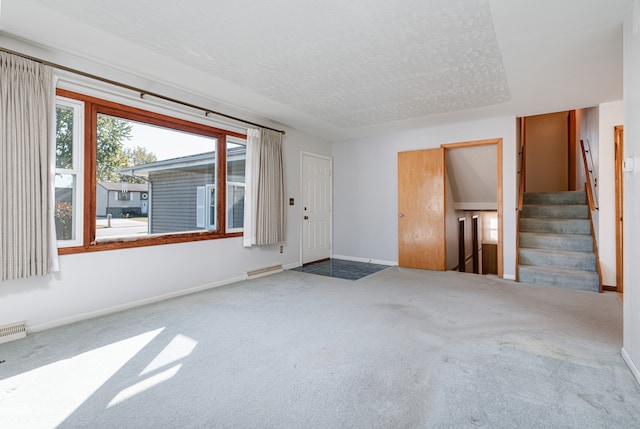 carpeted spare room with visible vents, stairway, baseboards, and a textured ceiling