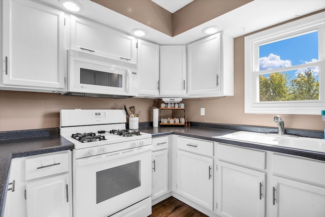 kitchen featuring white appliances, white cabinetry, sink, and dark wood-type flooring