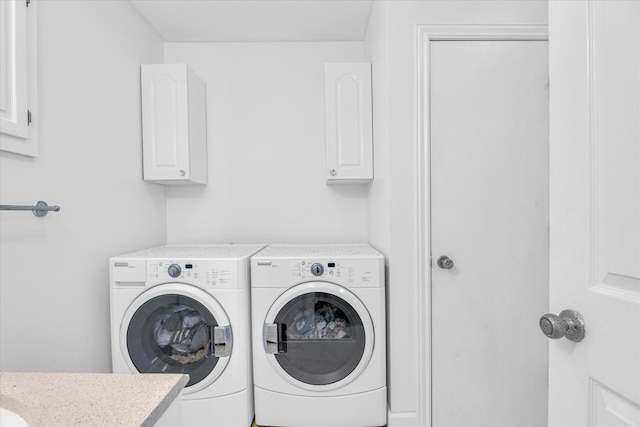 washroom with cabinets and washing machine and dryer