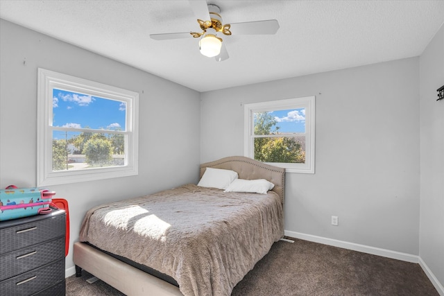 carpeted bedroom featuring ceiling fan and a textured ceiling