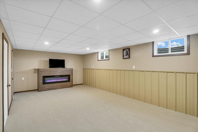 basement featuring light carpet and a paneled ceiling