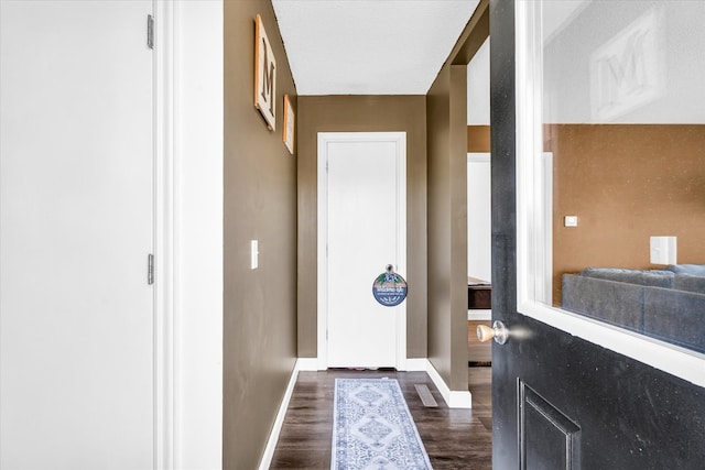 doorway to outside featuring a textured ceiling and dark hardwood / wood-style floors