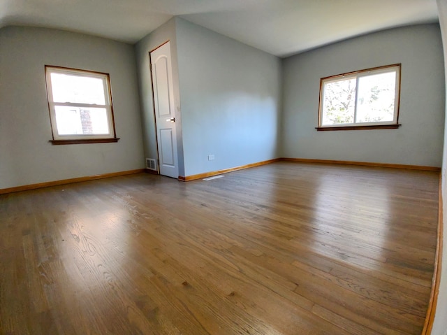 spare room featuring a wealth of natural light and light hardwood / wood-style flooring