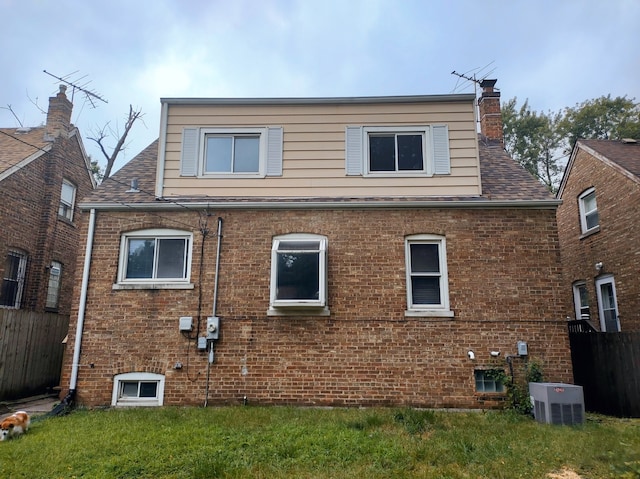 back of property featuring a lawn and central AC unit