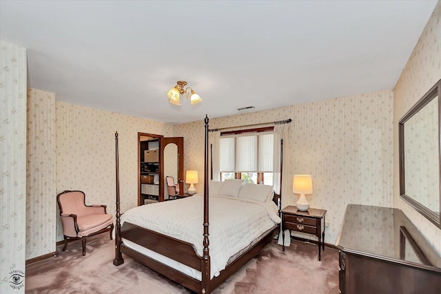 carpeted bedroom with visible vents, wallpapered walls, and baseboards