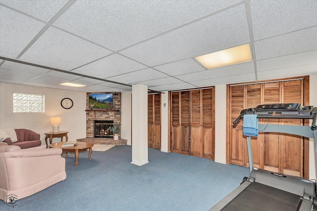 workout room featuring a brick fireplace, carpet, and a paneled ceiling