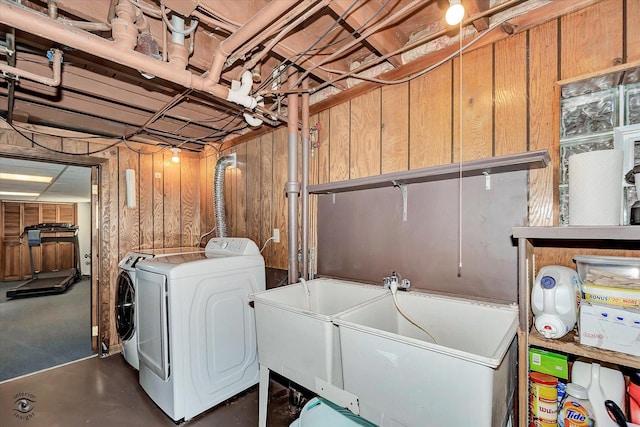 clothes washing area with wooden walls, independent washer and dryer, and laundry area