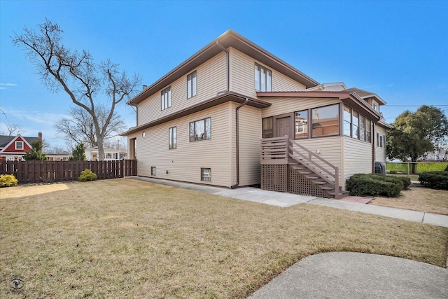 rear view of house with a yard and fence