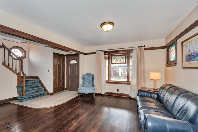 unfurnished living room with stairway, plenty of natural light, wood finished floors, and baseboards