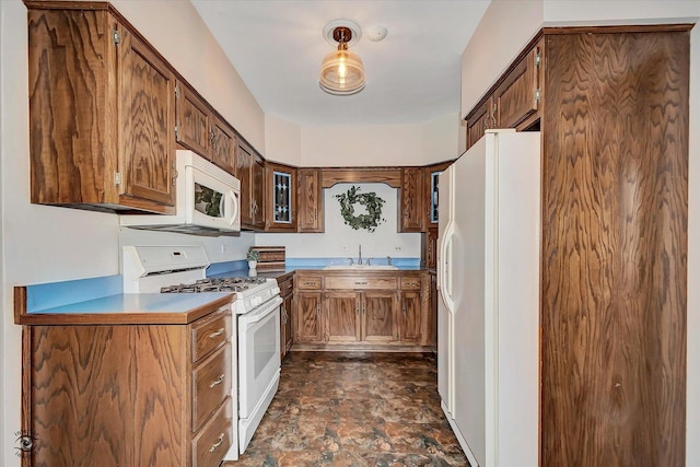 kitchen featuring a sink, white appliances, stone finish floor, and light countertops