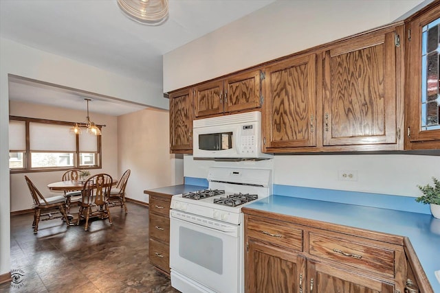 kitchen featuring decorative light fixtures, brown cabinets, white appliances, and baseboards