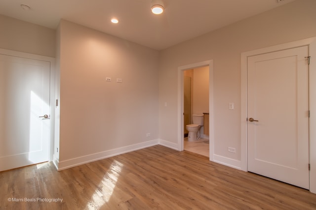 unfurnished bedroom featuring light hardwood / wood-style floors and ensuite bathroom