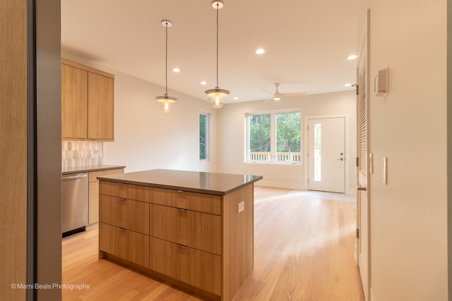 kitchen with stainless steel dishwasher, decorative backsplash, a center island, and light hardwood / wood-style flooring