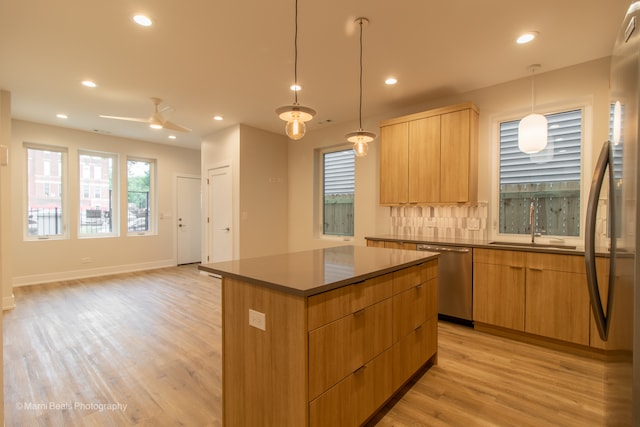 kitchen featuring light hardwood / wood-style flooring, hanging light fixtures, stainless steel appliances, sink, and a center island