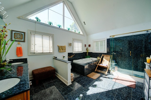 bathroom featuring vanity, high vaulted ceiling, and separate shower and tub