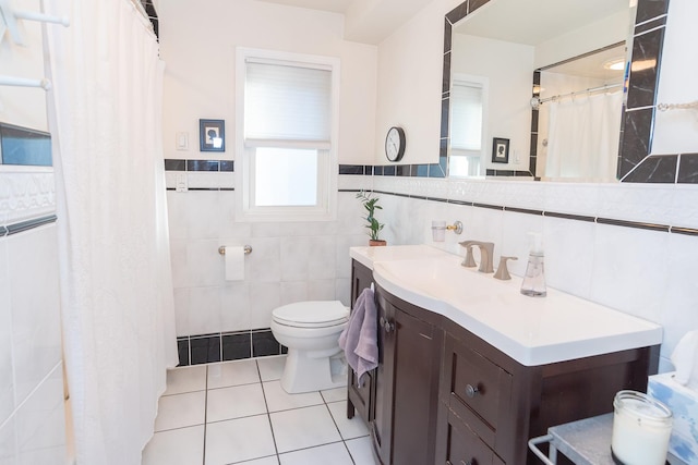 bathroom featuring vanity, toilet, tile patterned flooring, and tile walls