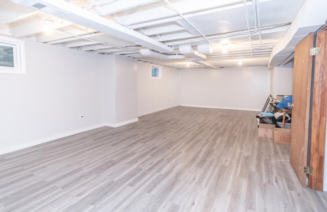 basement with light hardwood / wood-style flooring