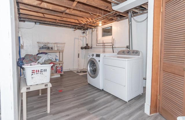 laundry room with wood-type flooring and washer and dryer