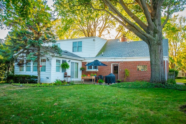 rear view of property featuring a yard