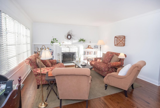 living room with wood-type flooring and ornamental molding