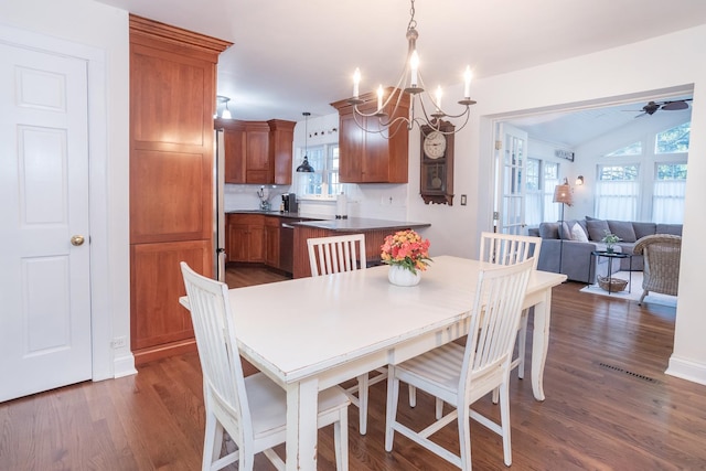 dining space with dark hardwood / wood-style floors and ceiling fan with notable chandelier