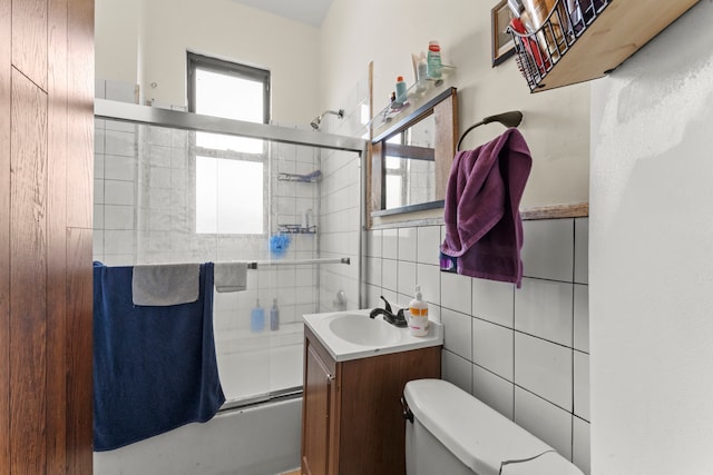 full bathroom featuring bath / shower combo with glass door, toilet, decorative backsplash, vanity, and tile walls