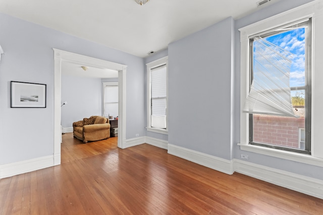 spare room featuring plenty of natural light and hardwood / wood-style flooring