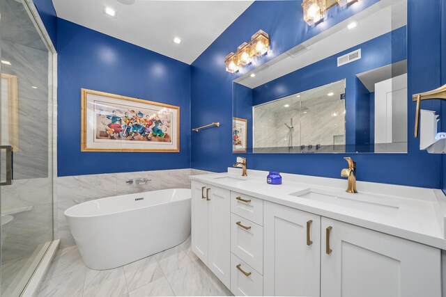 bathroom with vanity, independent shower and bath, and tile walls