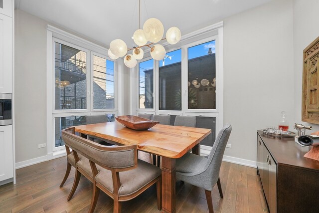 dining area with a notable chandelier and dark hardwood / wood-style floors