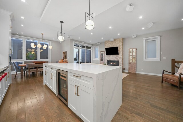 kitchen with a center island, white cabinetry, decorative light fixtures, wine cooler, and dark hardwood / wood-style floors