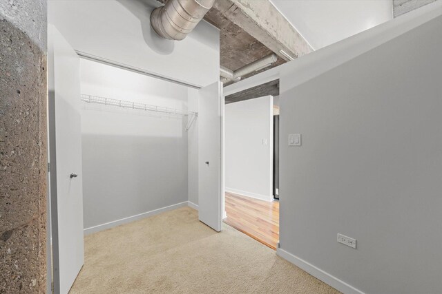 unfurnished bedroom with a closet and light carpet