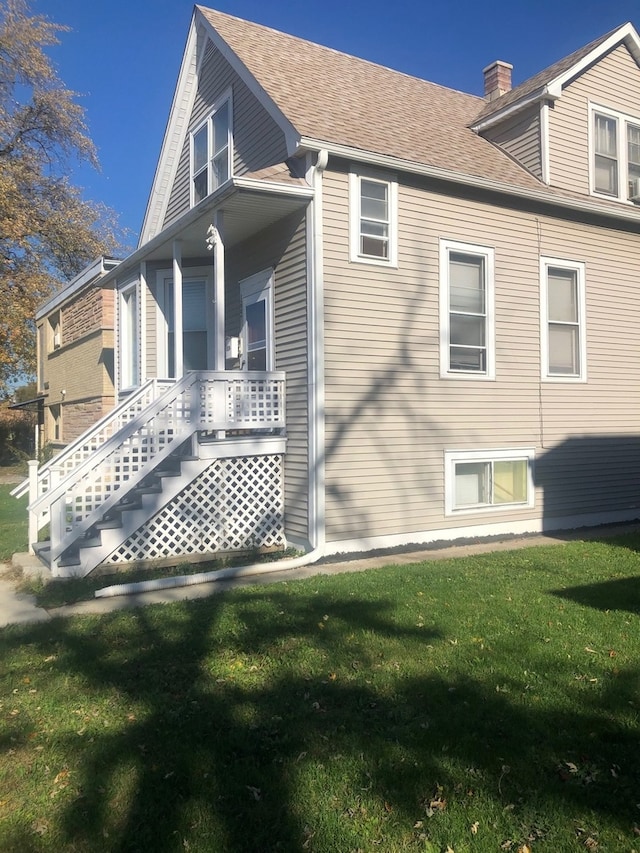 view of side of property with a porch and a yard