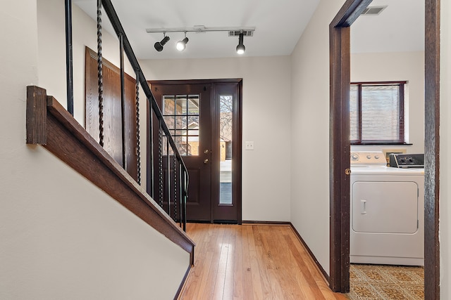 foyer featuring washer / dryer, track lighting, and light wood-type flooring