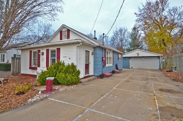 view of front of home with a garage and an outbuilding