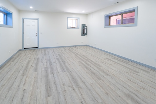 basement with electric panel and light wood-type flooring