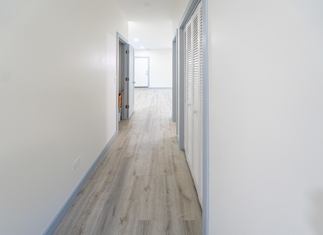 hallway with light hardwood / wood-style floors