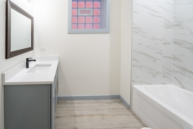 bathroom with vanity, hardwood / wood-style flooring, and a tub