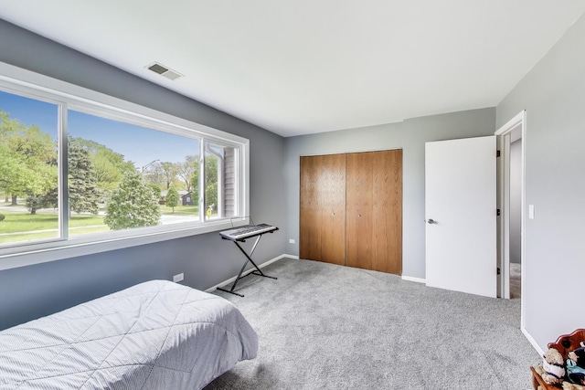 carpeted bedroom featuring a closet and baseboards