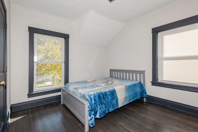 bedroom with vaulted ceiling, multiple windows, and dark hardwood / wood-style floors